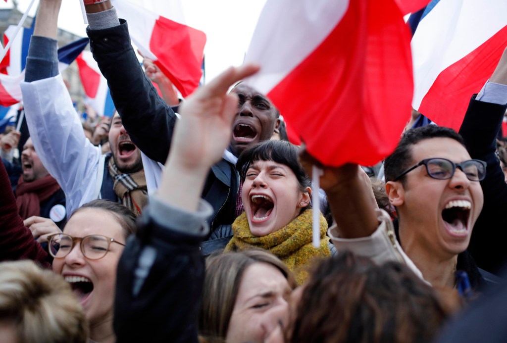 Supporters of Emmanuel Macron react outside the Louvre museum in Paris on Sunday.