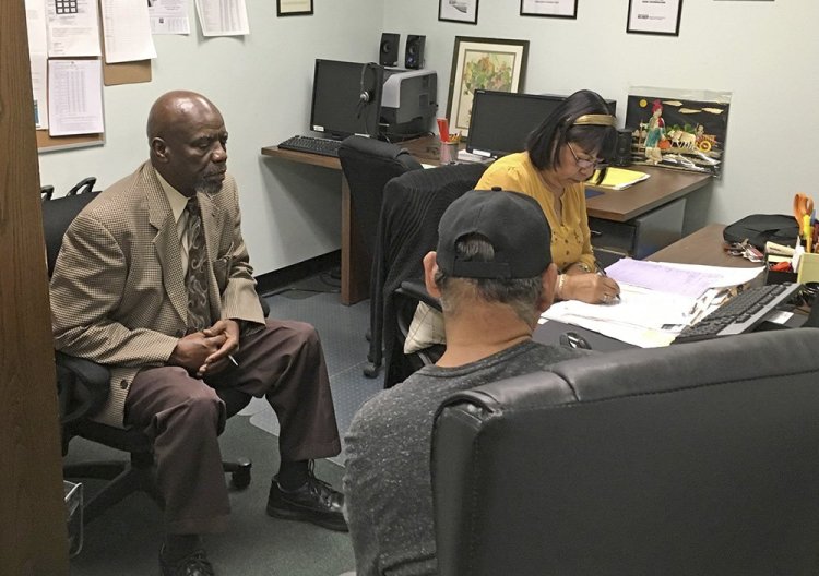 Nathan Singletary, 67, a social worker for 40 years, listens as Employment Specialist Luz Rivera, 68, interviews program participant Luis Quinones, 66, at the AARP Foundation in Harrisburg, Pa. 