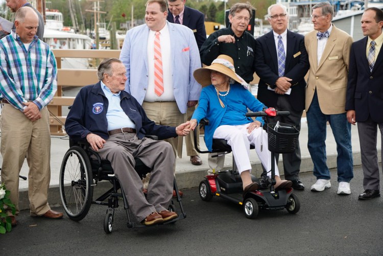 Former President George H.W. Bush and former first lady Barbara Bush hold hands while attending the rededication of the Mathew J. Lanigan Bridge over the Kennebunk River on Friday. The Bushes are staying at their summer home in Kennebunkport.