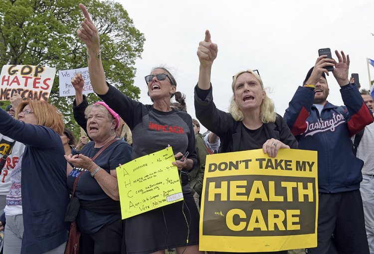 Protesters chant as Republican and Democratic House members walk down the steps of the Capitol  Thursday, after the Republican health care bill passed in the House. 