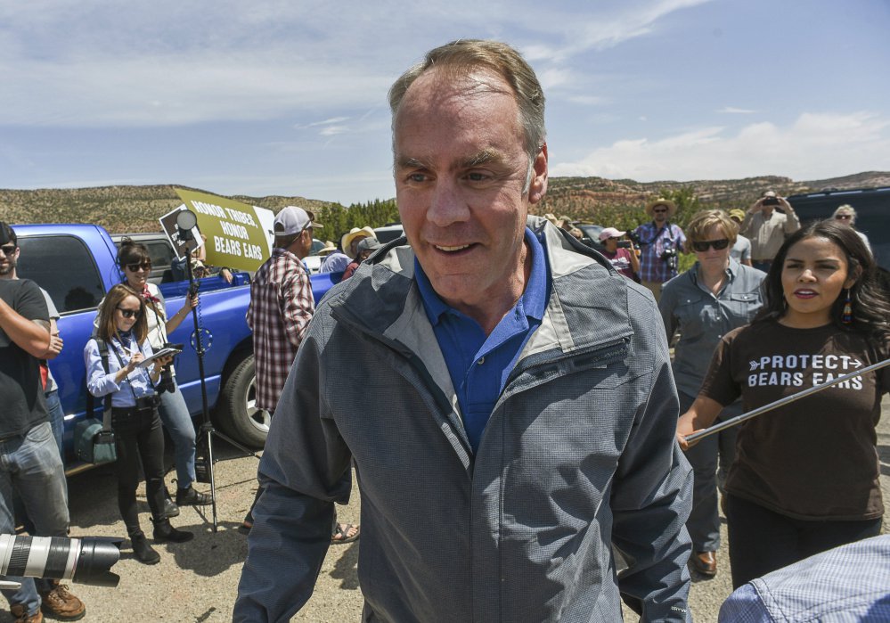 FILE - In this May 8, 2017, file photo, U.S. Interior Secretary Ryan Zinke arrives at the Butler Wash Indian Ruins trail head within Bears Ears National Monument in Utah as supporters of the monument crowd the parking lot. Zinke will have tens of thousands of comments to potentially look over as he prepares a recommendation next month for President Donald Trump about whether the new Bears Ears National Monument should be preserved, downsized or rescinded. (Francisco Kjolseth /The Salt Lake Tribune via AP)