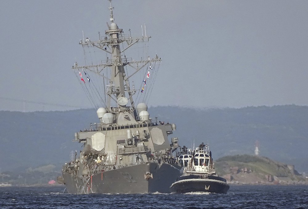 Tugboats guide the damaged USS Fitzgerald through waters near the U.S. naval base in Yokosuka, Japan. The destroyer collided on June 17 with the Philippine-registered container ship ACX Crystal, a much larger vessel. The guided-missile destroyer was built at Bath Iron Works and commissioned in 1995.