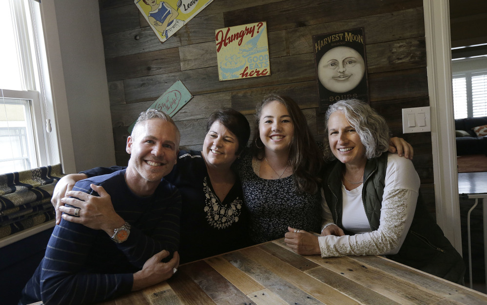 Madison Bonner-Bianchi, second from right, poses for photos with her parents, from left, Mark Shumway, Kimberli Bonner and Victoria Bianchi in Oakland, Calif. Madison says her relationship with her parents is like anyone else's – "I just happen to have three of them."