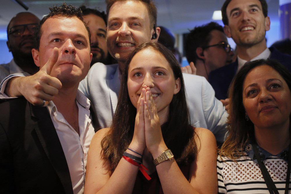 La Republique en Marche party members react after the announcement of the partial official results and polling agencies projections in the final round of parliamentary elections are announced at the party headquarters, in Paris, France, Sunday, June 18, 2017. Partial official results show President Macron's new centrist party with clear lead in parliamentary election.(AP Photo/Francois Mori)