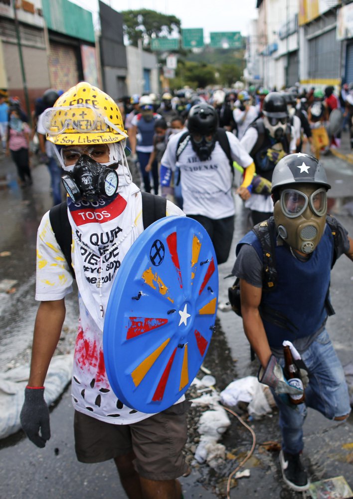 Anti-government demonstrators march in Caracas on Monday. Nearly 70 people have died in months of political unrest.