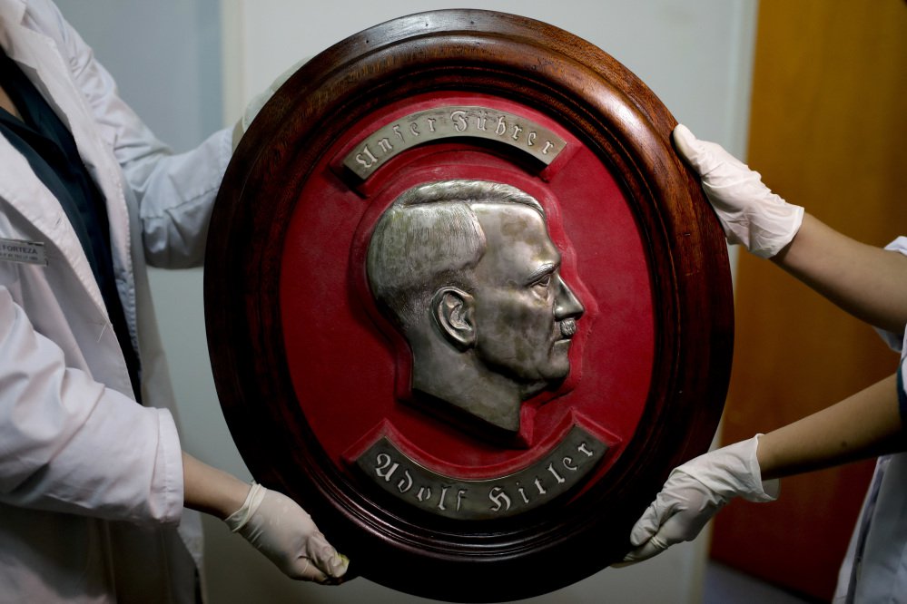 Members of the federal police show a bust relief portrait of Nazi leader Adolf Hitler at the Interpol headquarters in Buenos Aires, Argentina on Friday.