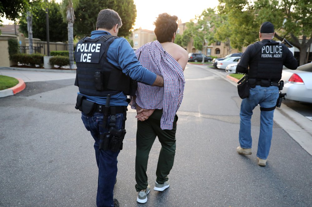 U.S. Immigration and Customs Enforcement agents arrest an Iranian immigrant in San Clemente, Calif., last month. A group of former detainees in Colorado is suing a private detention center company claiming they have been exploited for their labor.