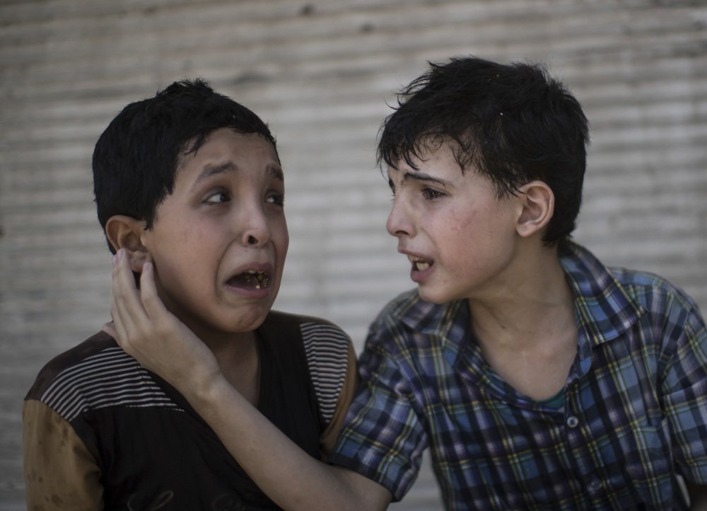 Cousins Zeid Ali, 12, left, and Hodayfa Ali, 11, comfort each other after their house was hit during fighting between Iraqi forces and the Islamic State in Mosul.
