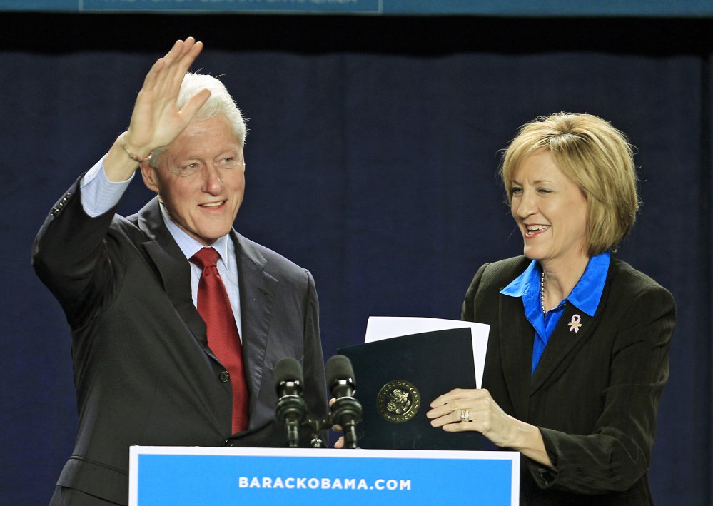 Bill Clinton waves after being introduced by U.S. Rep. Betty Sutton, D-Ohio, right, during a campaign event for President Barack Obama in Parma, Ohio, in 2012.