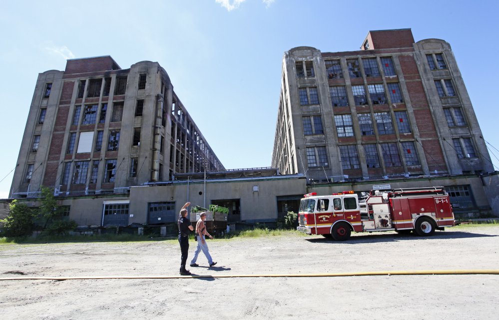 Sanford Fire Chief Steve Benotti and firefighter Todd Levesque keep an eye on hot spots Sunday at the Stenton Trust Mill Complex.