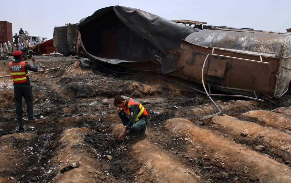 Pakistani rescue workers examine the site of an oil tanker explosion on a highway near Bahawalpur on Sunday. 