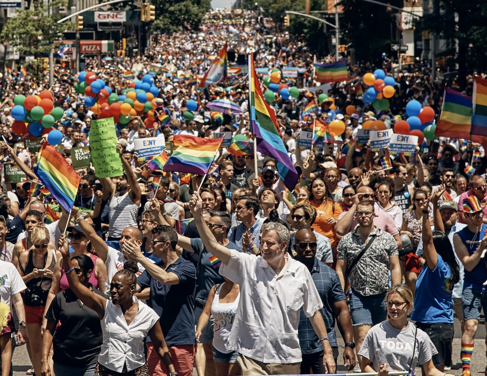 New York City Mayor Bill de Blasio, center, marches in the city's LGBT pride parade. Also Sunday, Gov. Andrew Cuomo appointed the first openly gay judge to the state Court of Appeals.