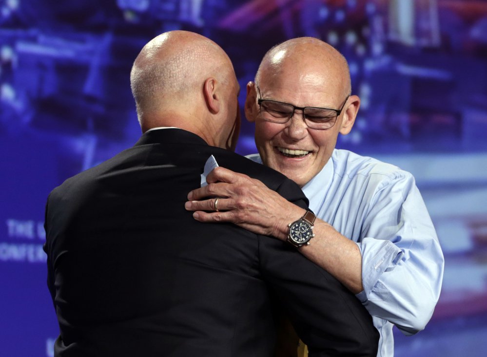 Political consultant James Carville, right, hugs New Orleans Mayor Mitch Landrieu following a speech at the annual U.S. Conference of Mayors meeting Monday in Miami Beach, Fla.