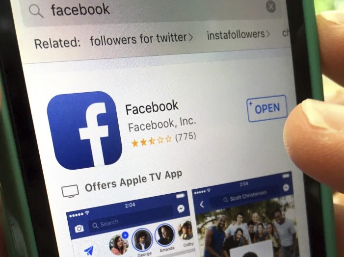 A Facebook page launches on an iPhone. The company defines hate speech as attacks based on race, sexual orientation and other "protected characteristics."