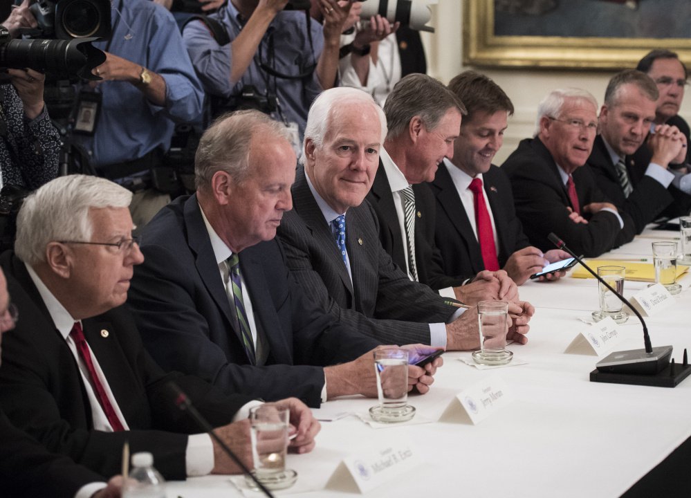 Senate Majority Whip John Cornyn, R-Texas, center, and others gather before the president arrives for a meeting with Republican senators about health care Tuesday.