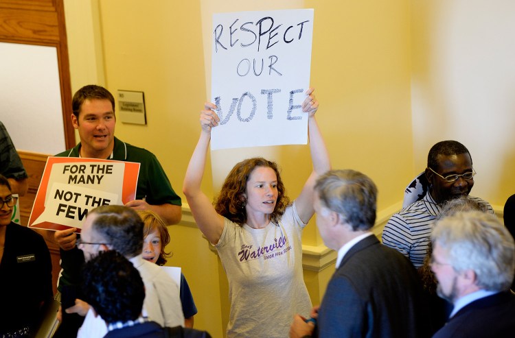 Ciara Hargrove, a teacher in Waterville, protests at the State House on Tuesday against a state shutdown.