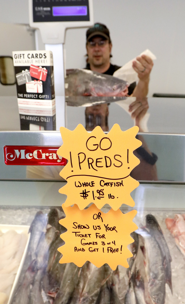 Harvey Harris weighs a catfish at Little's Fish Market in Nashville, Tennessee. The store is offering a free catfish to anyone showing a ticket for Game 3 or 4 to the NHL Stanley Cup Finals.
