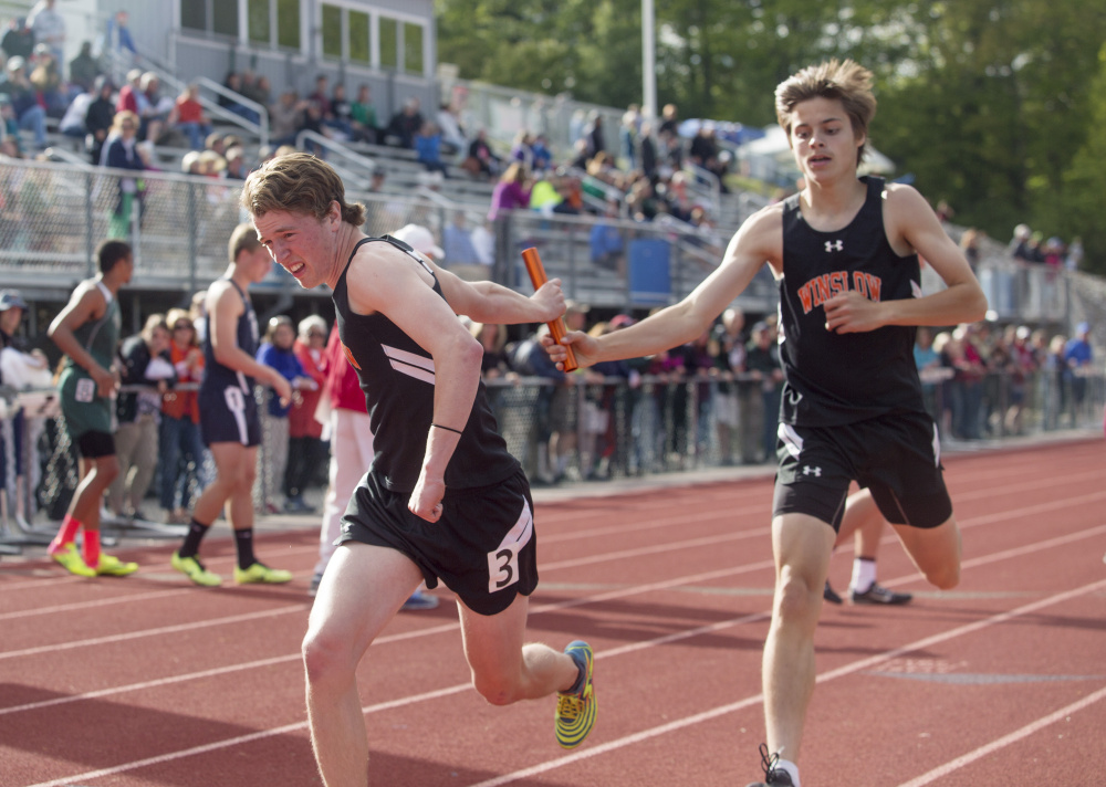 Winslow senior Spencer Miranda hands off the baton to Ben Smith during the 4x400 relay race at the Class B track and field state championship meet Saturday in Yarmouth.