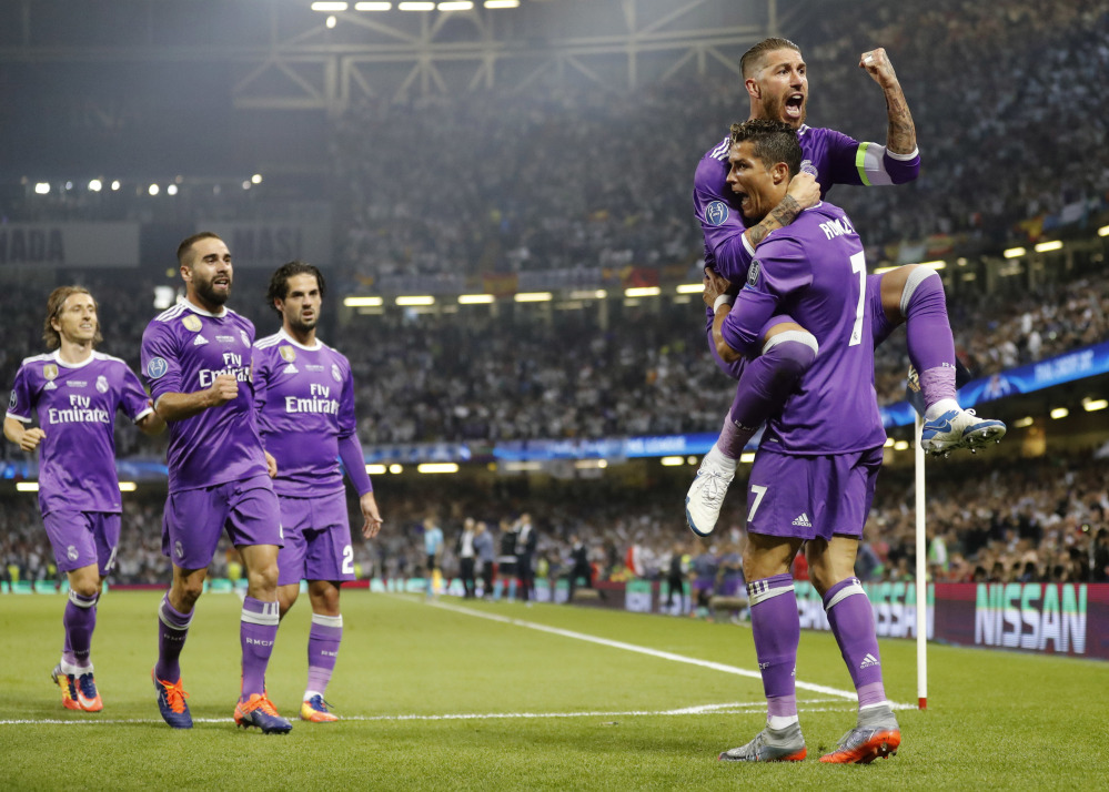 Real Madrid's Cristiano Ronaldo celebrates with Sergio Ramos, top, after scoring the opening goal during the Champions League final soccer match against Juventus Saturday at the Millennium stadium in Cardiff, Wales.