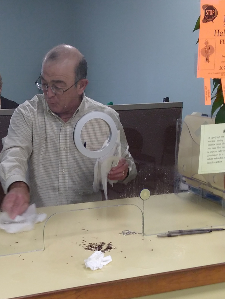 Ralph St. Pierre, Augusta's finance director and assistant city manager, picks up bed bugs that were reportedly spilled by a disgruntled man Friday afternoon at Augusta city hall.