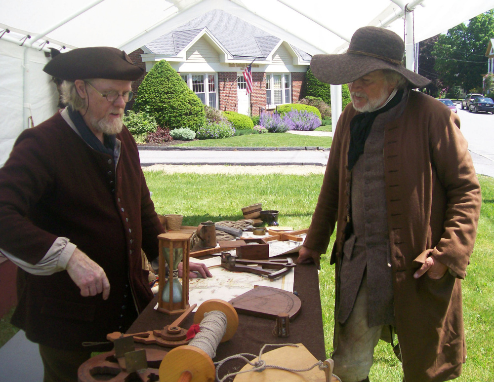 Jeff Miller, left, and Paul Daiute discuss maps, charts and navigational instruments used during the Colonial Era.