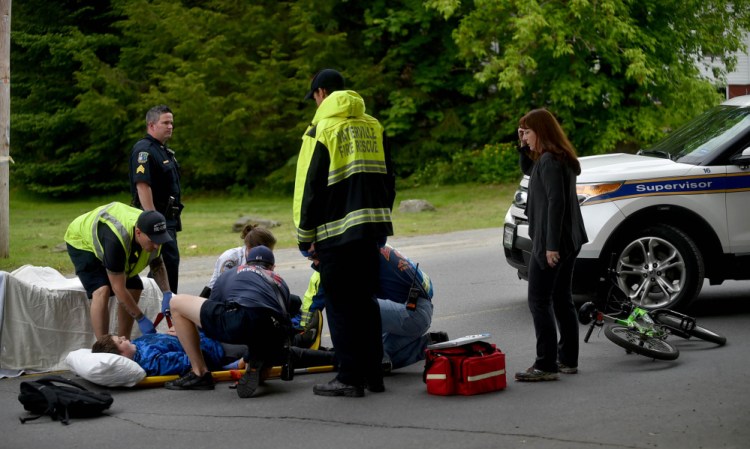 Paramedics from the Waterville Fire Department treat a boy who struck a car while riding his bicycle Tuesday on Western Avenue in Waterville.