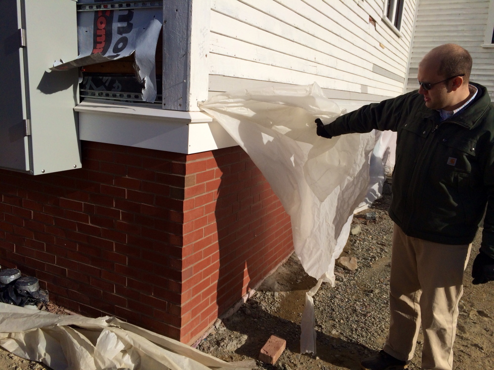 Matt Tremblay, manager of the Unity Food Hub, shows new brick siding on the former Unity Grammar School in January 2015. Renovation to convert the old school into a food hub was funded in part by federal grants.