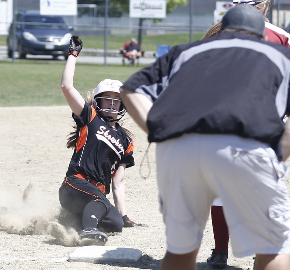 Skowhegan runner Sydney Ames slides safely into third base as coach Lee Johnson looks on during an A North semifinal game against Bangor on Saturday. The Indians will play Oxford Hills in the regional final.