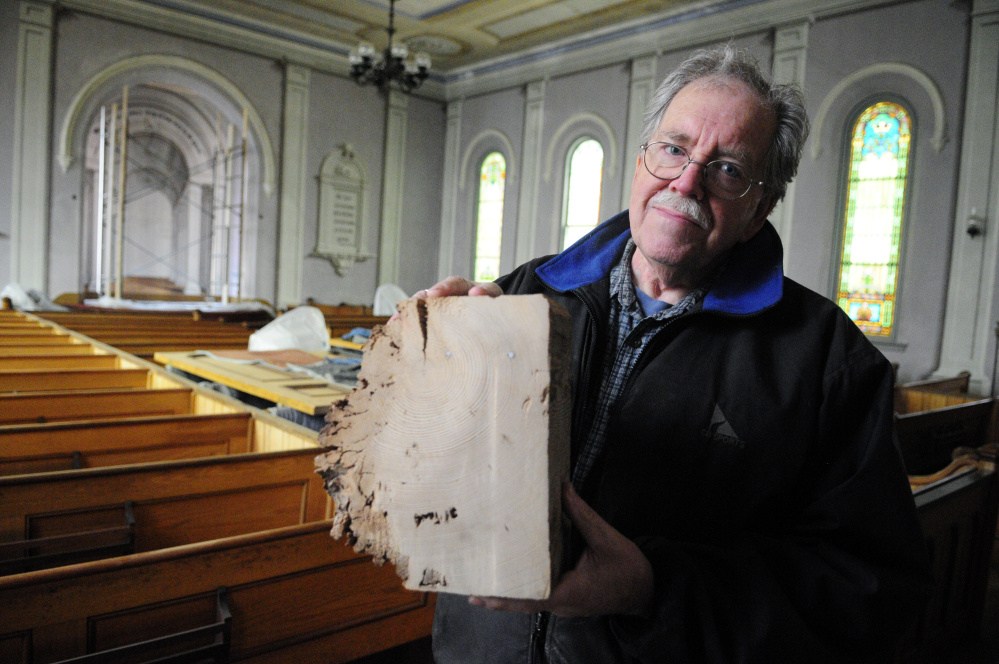 John Perry holds up piece of a beam that needed to be replaced April 21 in the Readfield Union Meeting House. Voters on Tuesday agreed to spend $5,000 toward the cost of rehabilitating the old building.