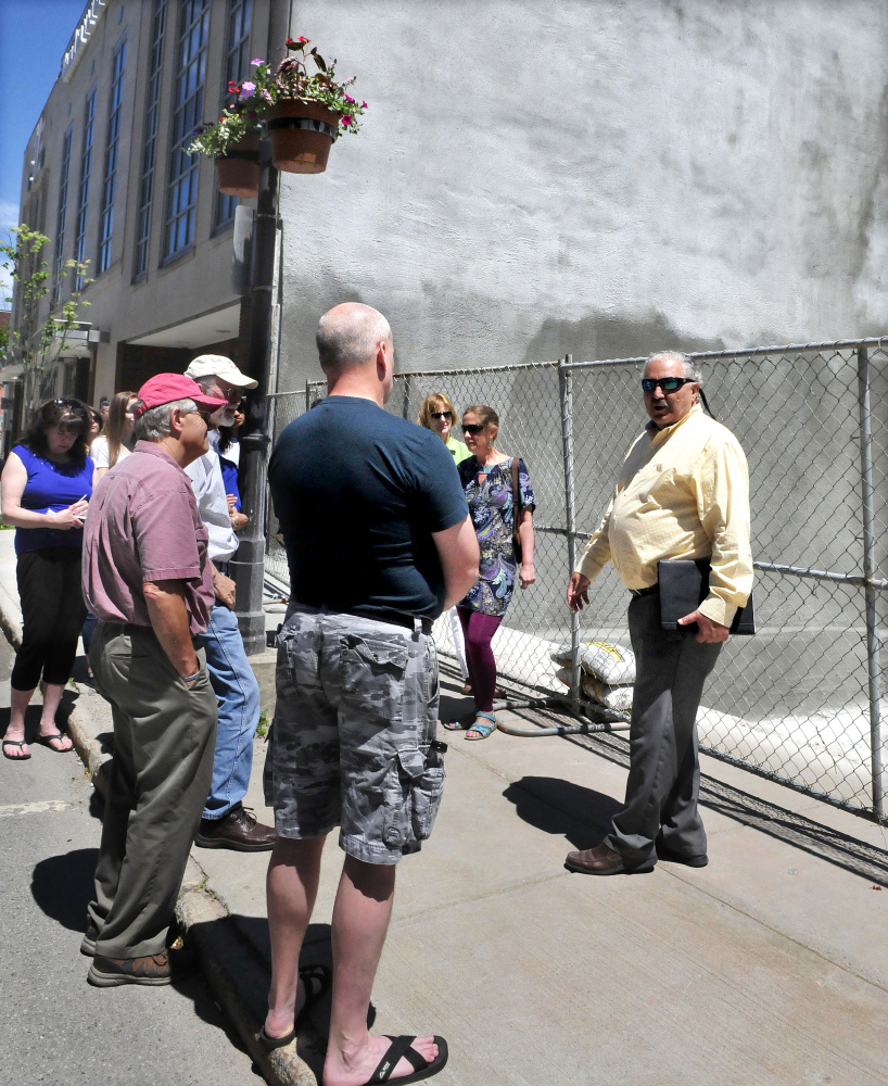 Paul Ureneck, right, leads a group of people Wednesday on a downtown Waterville tour of various ongoing revitalization projects, including the former Levine's store.