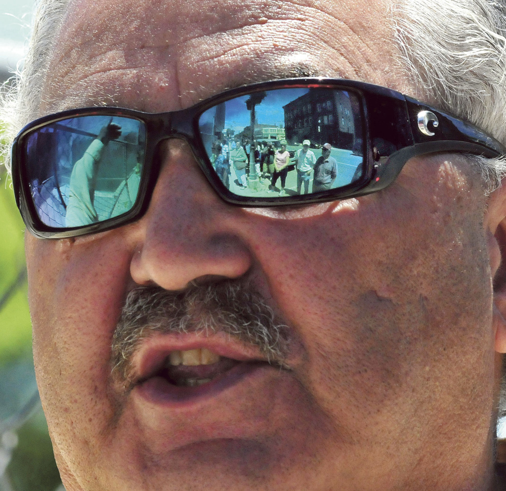 Paul Ureneck leads a group of people, seen in a reflection in his glasses,  on a downtown Waterville tour Wednrsdau of various ongoing revitalization projects, including the former Levine's store.