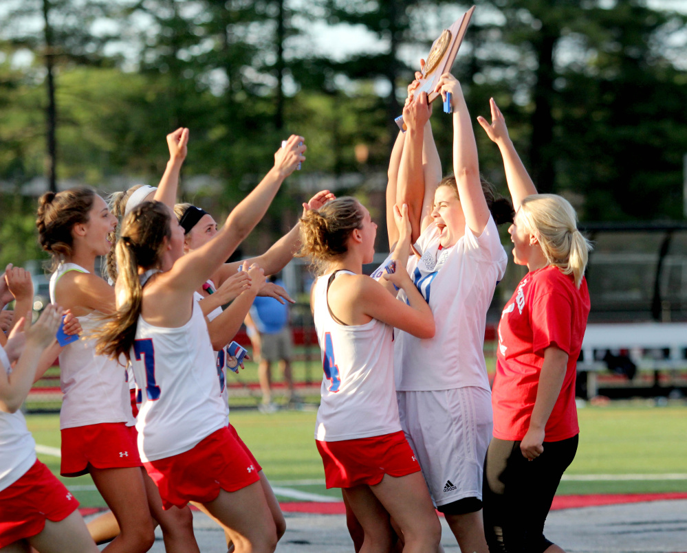 Messalonskee goalie Gaby Languet holds up the Class A North championship plaque after the Eagles sank Windham 7-6 Wednesday at Thomas College.