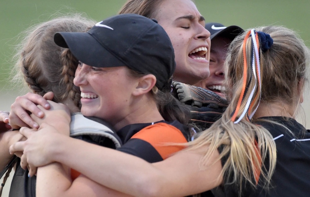 Members of the Skowhegan softball team celebrate their 5-4 win over Oxford Hills in the Class North championship game Wednesday at Cony High School.