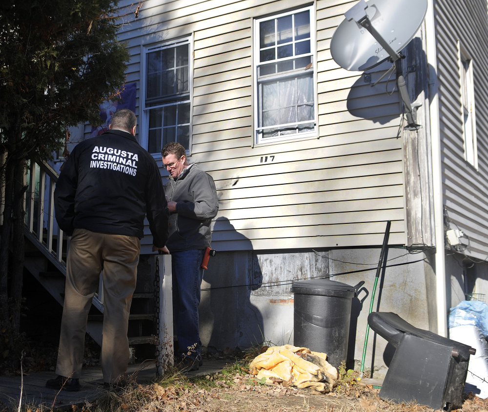 Augusta police Lt. Chris Massey, left, and Augusta Code Enforcement Officer Robert Overton inspect the apartment building at 117 Bridge St. in Augusta in 2016 after police executed a search warrant at the building and arrested two people on drug trafficking charges. The city now owns the property, which is next door to one that the council voted Thursday to purchase.