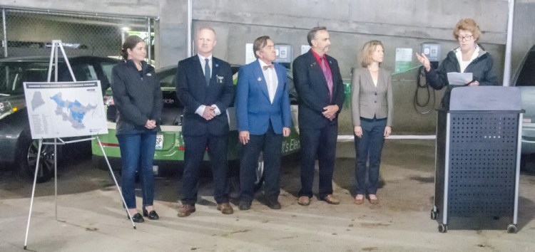 Sara Burns, president and chief executive officer of Central Maine Power Co., right, speaks at the electric car charger ribbon-cutting event Friday in the State House parking garage in Augusta.