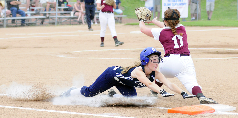 Greenville's Jessica Pomerleau slides safely into first base as Richmond's Cassidy Harriman waits for the throw during the Class D South regional final Tuesday at St. Joseph's College in Standish.