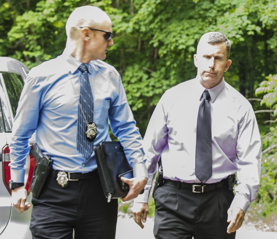 Detective Benjamin Sweeney, left, and Sgt. Christopher Tremblay, both of the Maine State Police, confer on Saturday at the scene of a fatal shooting off Yeaton Drive in West Gardiner, The victim, James Haskell, 41, was a visitor at the property, according to Steve McCausland, spokesman for the Maine Department of Public Safety.