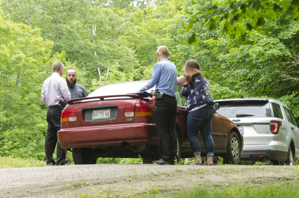Sgt. Christopher Tremblay, left, and Detective Benjamin Sweeney, second from right, both of the Maine State Police, talk on Saturday afternoon on Yeaton Drive in West Gardiner with relatives of a man who was shot to death there early that morning. The victim, James Haskell, 41, was a visitor at the property, according to Steve McCausland, spokesman for the Maine Department of Public Safety.