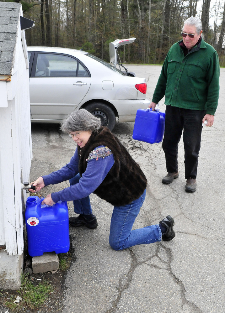 Connie Bellett and her husband, Phil Frizzell, fill water containers May 10 at the Windsor Town Office. The couple transported the water 8 miles to the Community Garden in Palermo to water growing vegetables. The Malcolm Glidden American Legion Post 163 has refused to connect a water supply to the rental space.