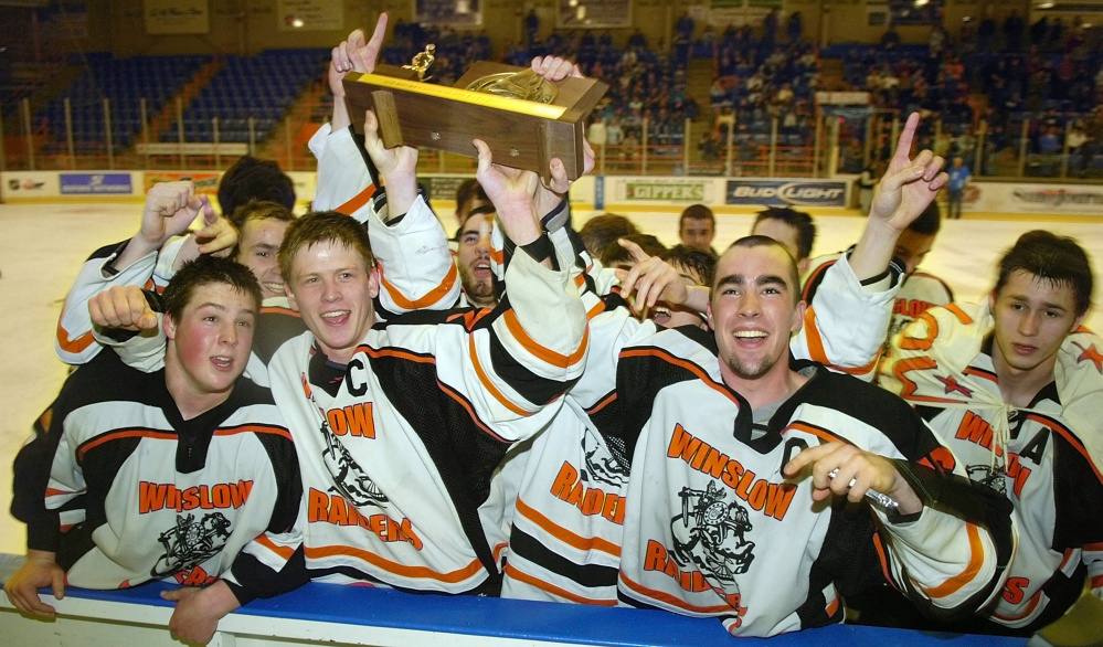 Winslow Raiders celebrate with their trophy after beating York 4-3 in overtime to win the class B state hockey championship on Saturday at The Colisee in Lewiston.