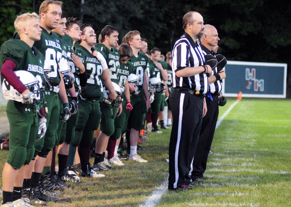 Members of the Winthop/Monmouth football team and officials stand during the national anthem prior to a Campbell Conference Class D game against Dirigo last season in Winthrop. There is growing momentum to add Hall-Dale to the co-op.
