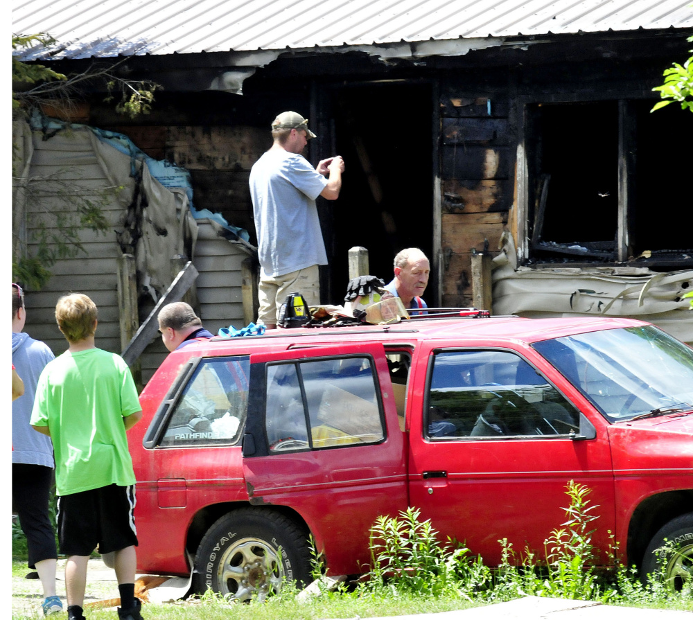 Homeowner Tyler Bishop photographs the damage after fire destroyed his home Thursday on Higgins Road in Pittsfield. Firefighters from several area departments battled the fire.