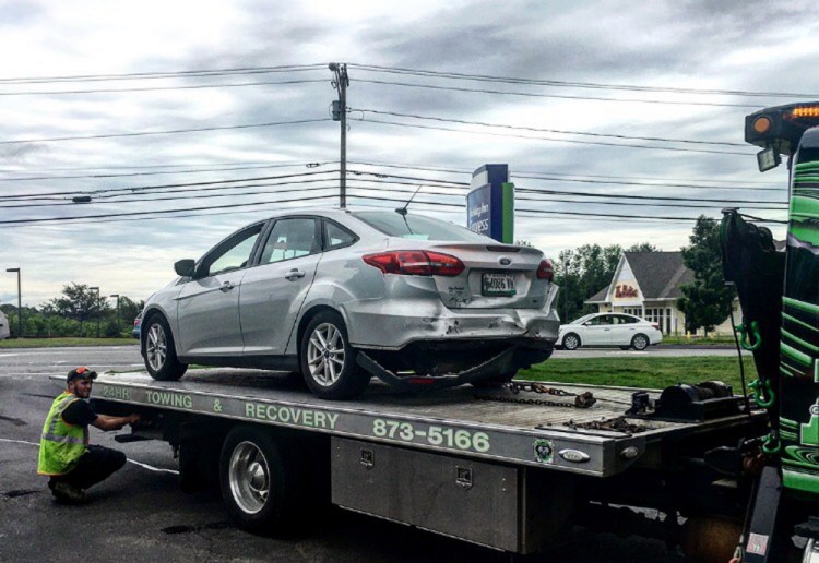 A tow truck removes one of two cars involved in a rear-end crash Saturday morning on upper Main Street in Waterville that, according to police, injured both drivers slightly.