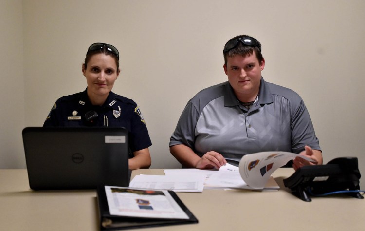 Officer Linda Smedberg, left, of the Waterville Police Department, works with intern Kyle Schmitz at the police department Thursday. Working with the department's HOPE program that focuses on helping addicts has been an eye-opener for both.