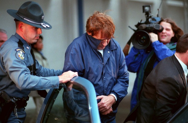 Albert Cochran is escorted by Maine State Police on March 21, 1998, to a waiting police cruiser at Portland International Jetport. Cochran returned to Maine from Florida to face murder charges in the death of Janet Baxter, of Oakland, in 1976.