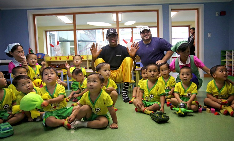 Former NBA basketball star Dennis Rodman sits with children from the Pyongyang orphanage and nursery that he visited Thursday. 