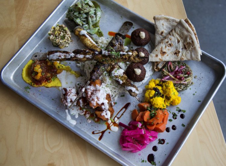 The All In, a large-format sharing plate with kabobs, mezze, spreads, pickles, sauces and Iraqi flatbread.
