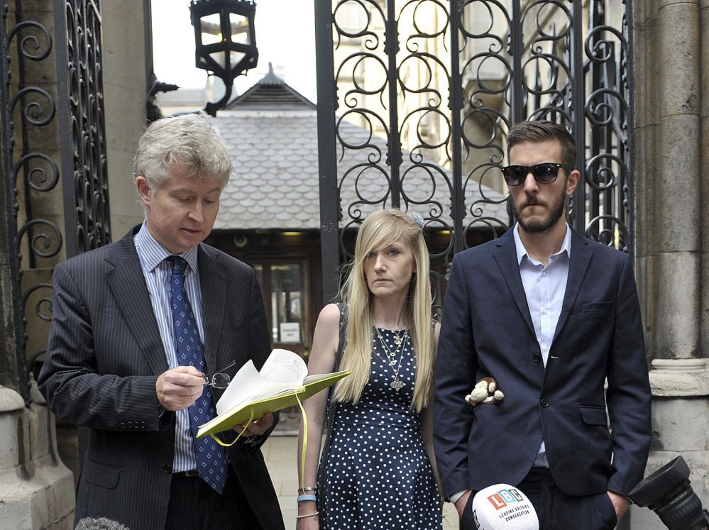 The parents of sick baby Charlie Gard, Connie Yates and Chris Gard, right, listen as a statement is read by a family friend outside the High Court in London recently.
