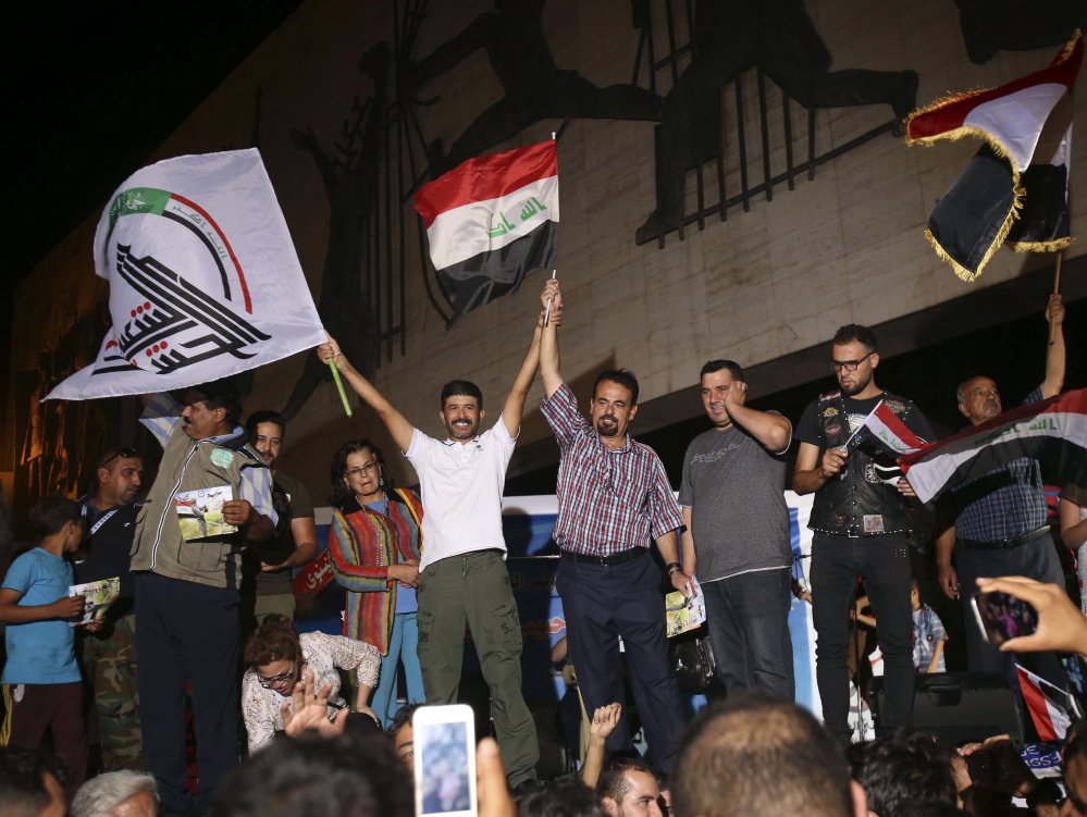 Iraqis wave national flags in Baghdad's Tahrir square on Monday, celebrating news of the army's victory in Mosul after nearly nine months of grueling urban combat against Islamic State extremists. Coalition airstrikes earlier Monday pounded the last ISIS-held territory.
