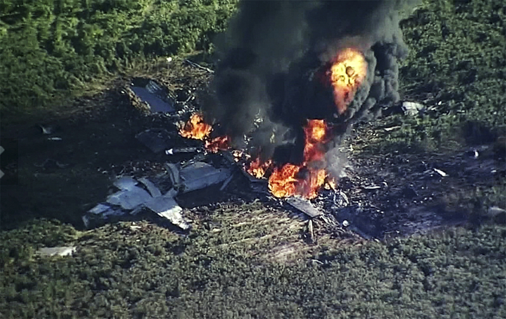 Smoke and flames rise from the military plane that crashed in a farm field, in  Mississippi, killing 16 people.
